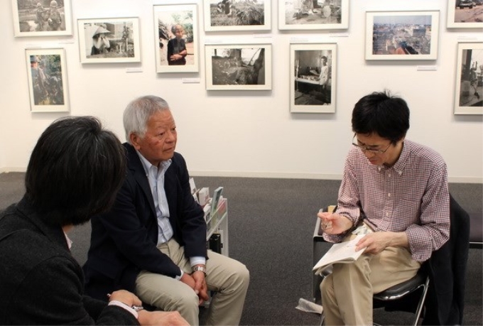 Nhiếp ảnh gia Ishikawa Bunyo (giữa) trả lời các phóng viên Nhật Bản về cuộc triển lãm ở Tokyo. (Ảnh: TTXVN)